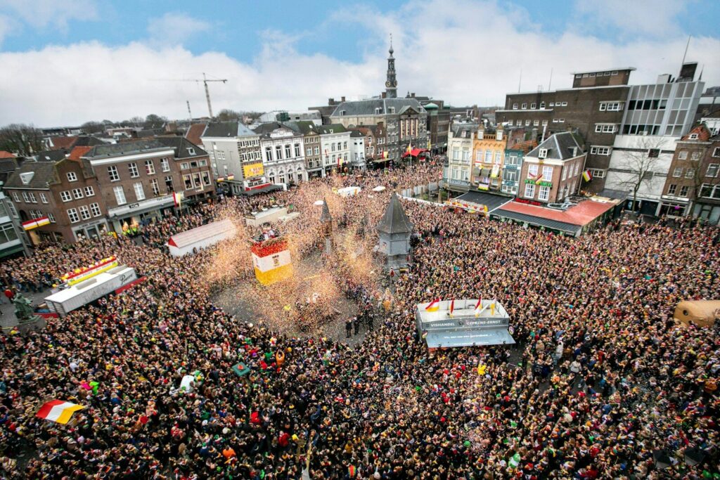 Crowded city square with festive parade and buildings