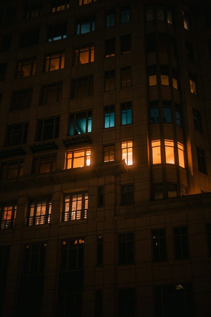A stone building facade at night with glowing amber and teal windows in Washington