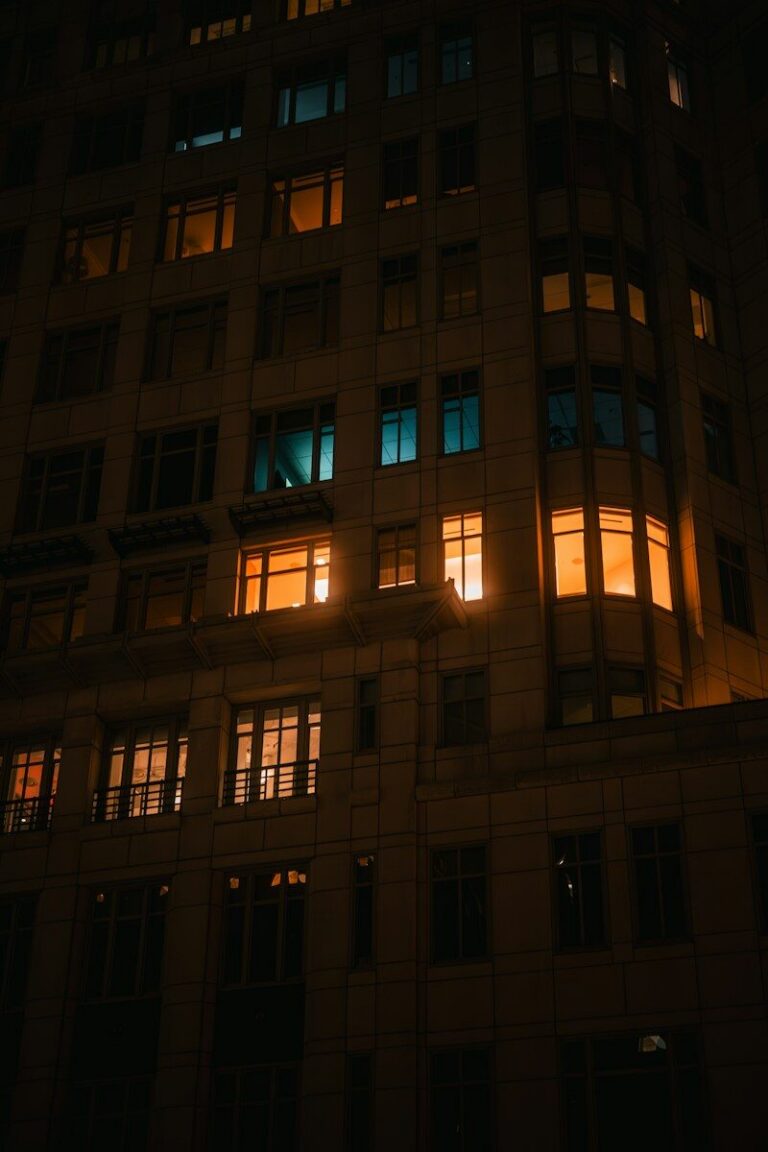 A stone building facade at night with glowing amber and teal windows in Washington