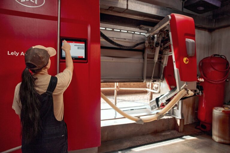 Woman operating a robotic milking unit