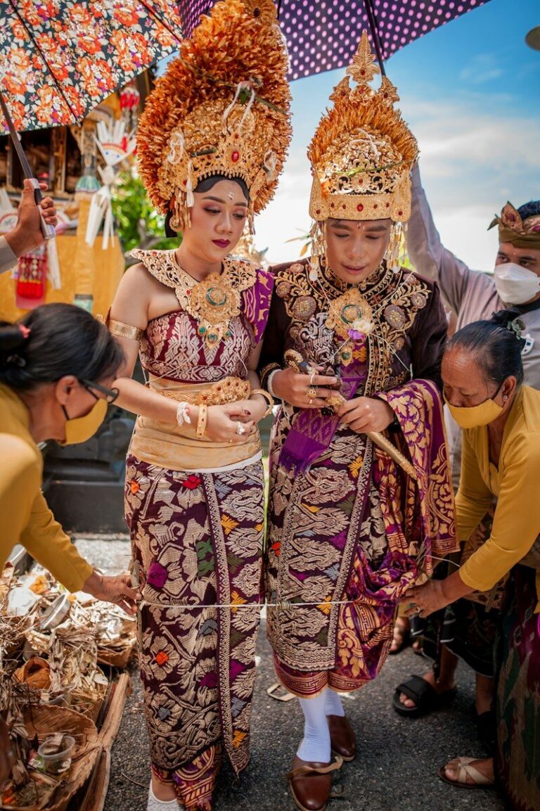 woman in purple and white floral dress standing beside woman in yellow and red sari dress